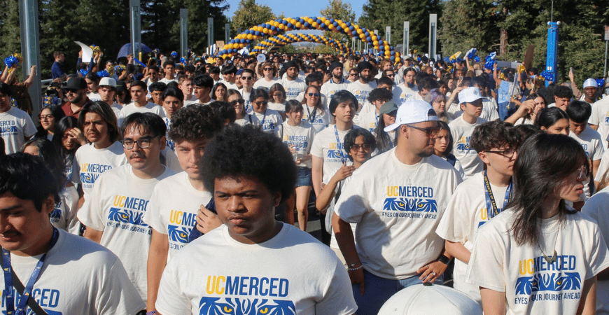New students walking across Scholars Bridge