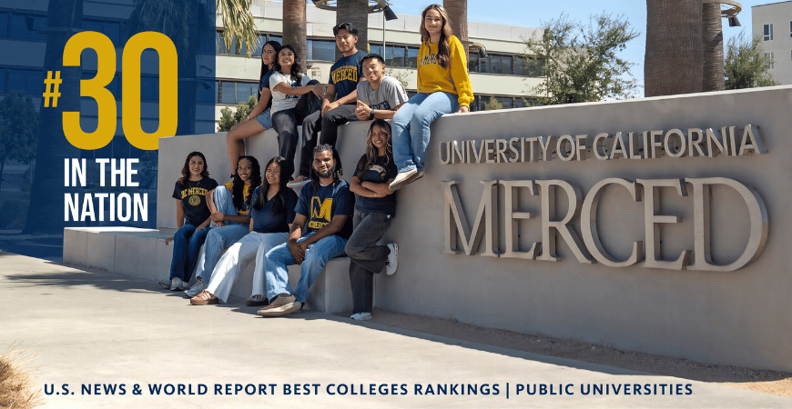 Students gathered around a UC Merced sign,