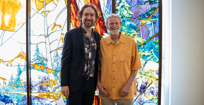 Two men standing in front of a mural
