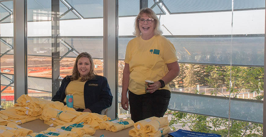 two women in yellow shirts laughing