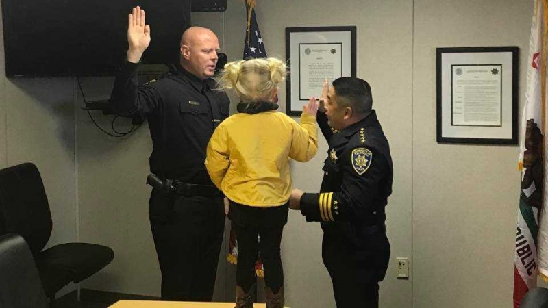 James Andrew Marshall is sworn in by UC Merced by Police Chief Chou Her as Marshall's 3-year-old daughter looks on.