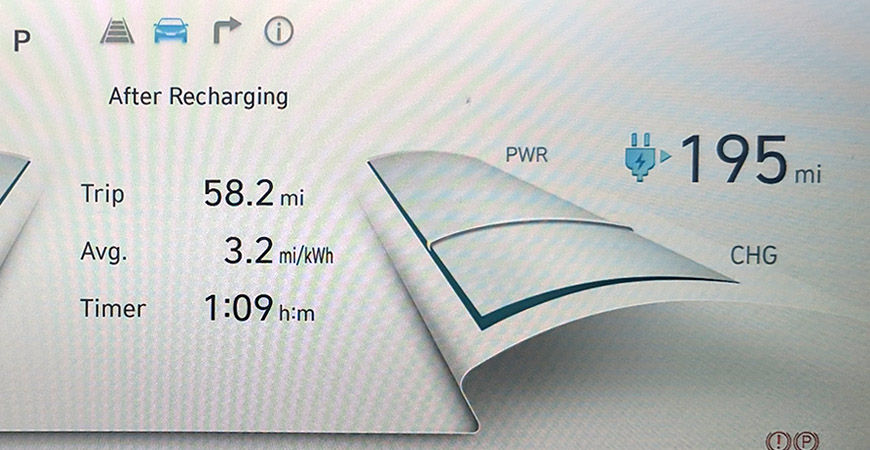 An electric vehicle dashboard display includes a timer, trip length and estimated remaining mileage.