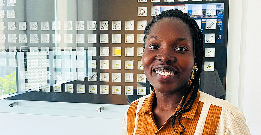 Black female grad student in chemistry and biochemistry with dark hair and orange blouse