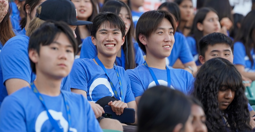 Students wearing blue shirts emblazoned with the COSMOS logo sit in the stands at a Fresno Grizzlies game.