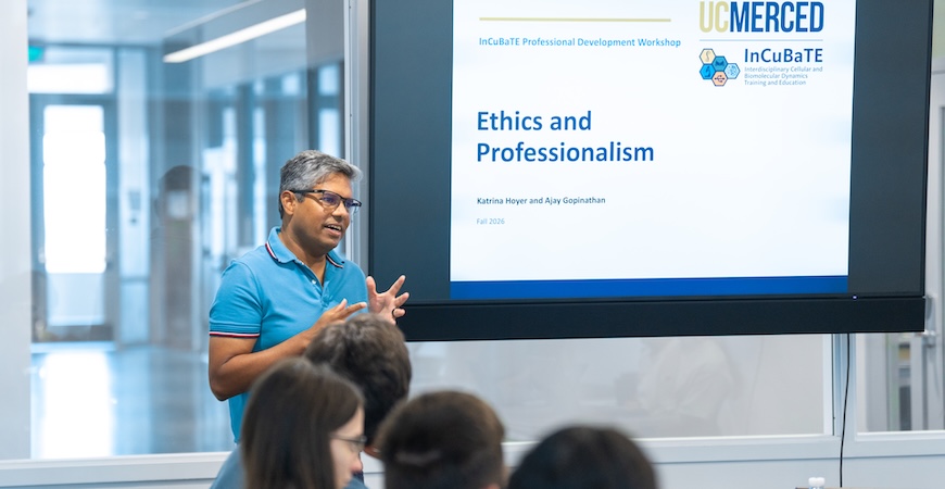 Professor Ajay Gopinathan speaks to students in front of a screen reading "Ethics and Professionalism."