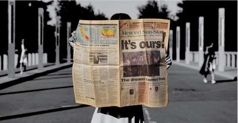 A student holds a copy of the Merced Sun-Star, with a large headline proclaiming "It's Ours!"