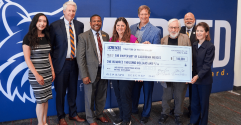 Leadership from Las Positas and UC Merced Board of Trustees pose with big check