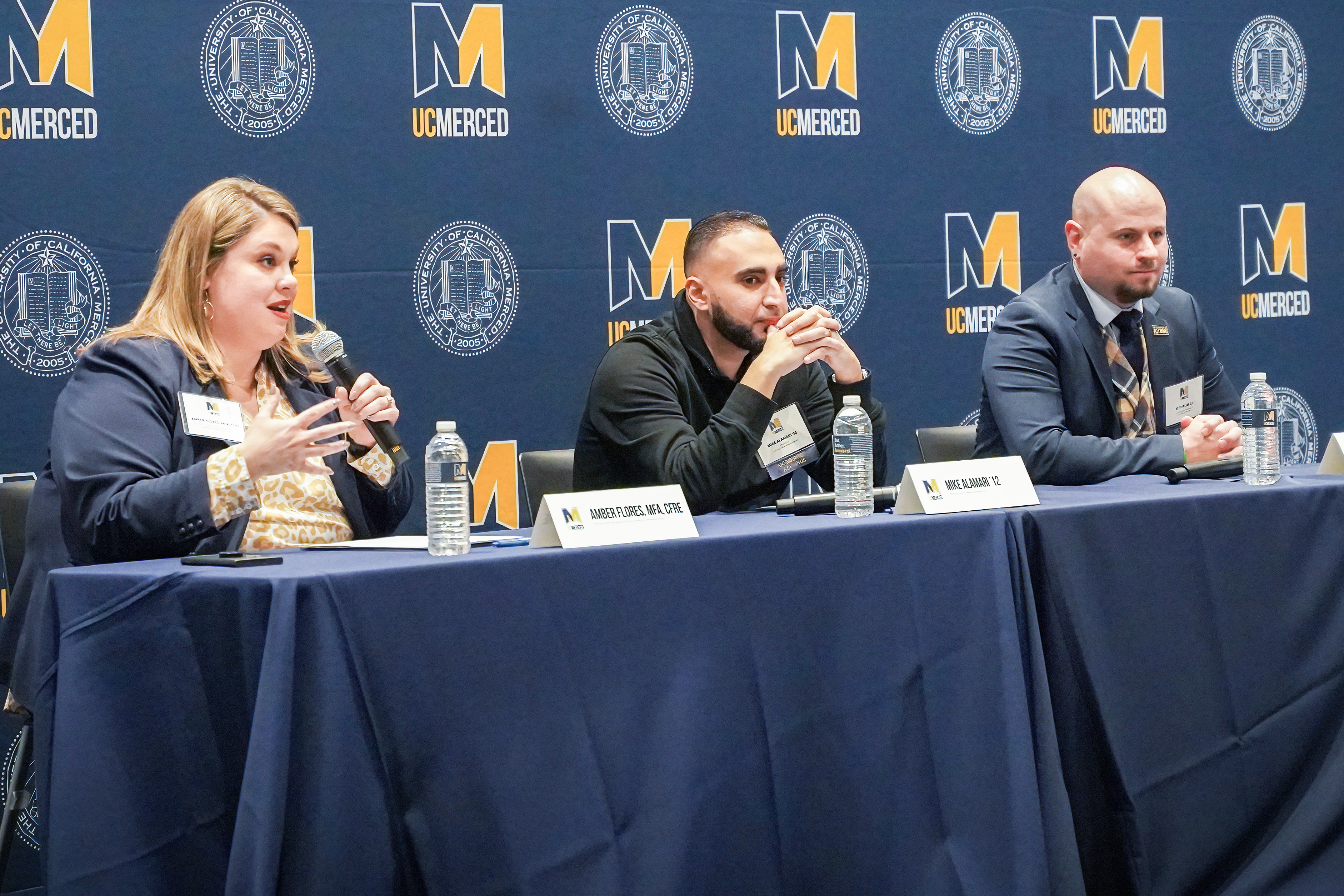 Three people sit behind a table at the "Champvocates Dinner."