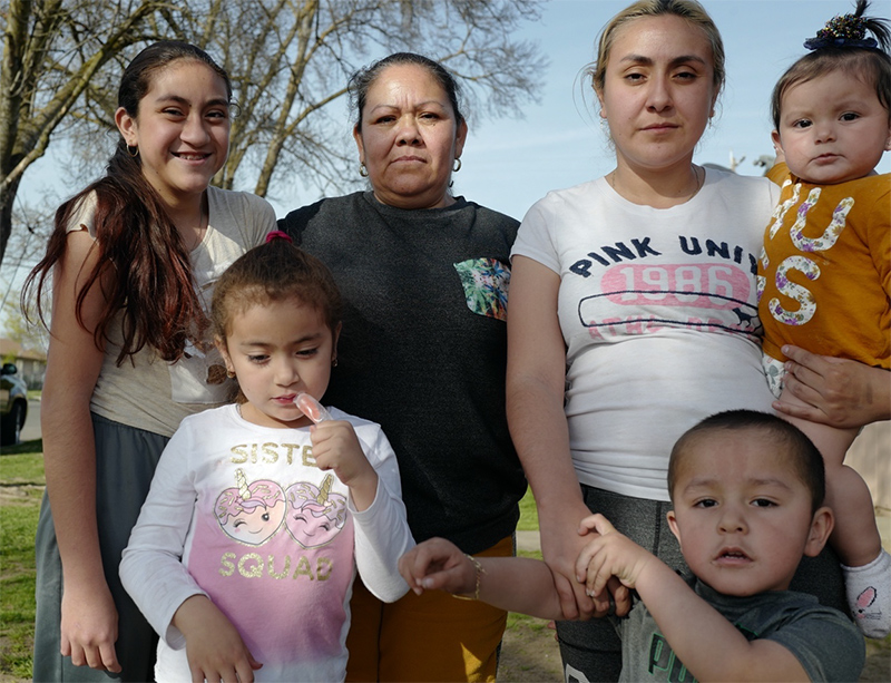 A group of adults and children gather for a photo in Merced.