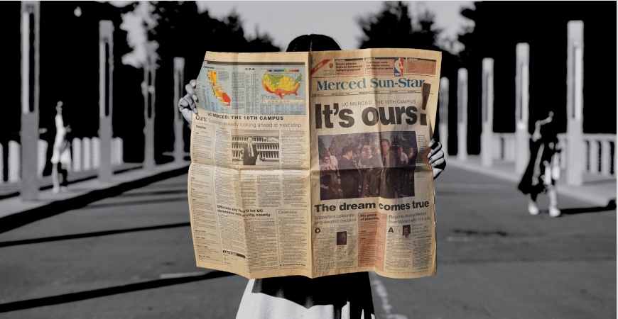 A student holds a copy of the Merced Sun-Star, with a large headline proclaiming "It's Ours!"