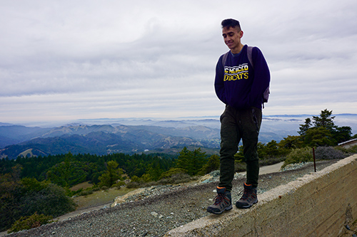 Adrian Buitron Boada, a student in the Leadership & Service Living Learning Community, walks along a wall atop Mount Tamalpais.