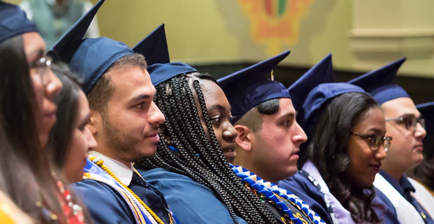 Graduating students listen to a speaker during commencement.