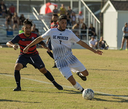 A UC Merced men's soccer player prepares to shoot.