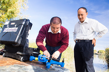 professor Chen, right, and student Brendan Smith work with drones.
