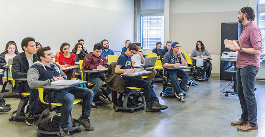 Professor lectures in front of class of college students