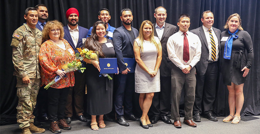A group poses for a photo at the Alumni Signature Ceremony on the UC Merced campus.
