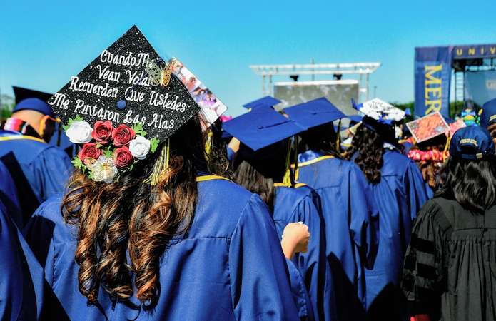 A mortarboard with a Spanish inscription is displayed at UC Merced commencement.