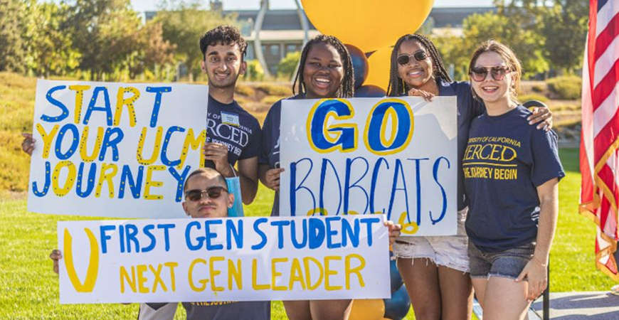 Current students holding signs welcoming new students