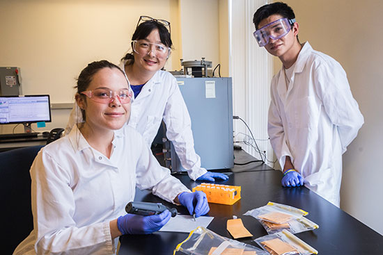Professor Kim and two undergraduate students occupy her lab.