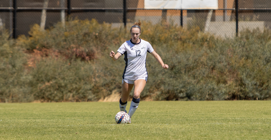 Maddie Door plays soccer on a field.