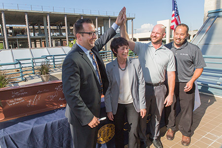 Local officials standing in front of building construction