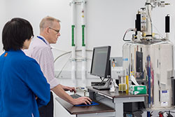 Dave Russell, NMR facility manager, shows a student how to use the equipment.