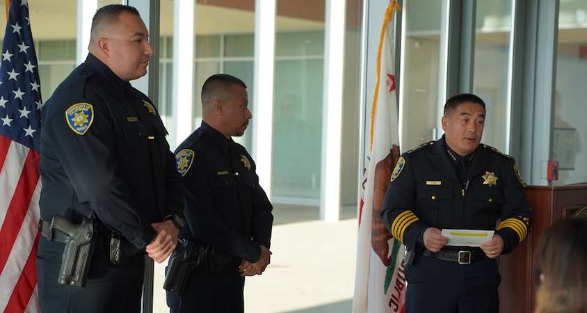 Officers Brian Carbaugh and Enrique Rodriguez receive awards from UC Merced Police Chief Chou Her. 
