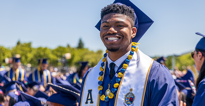 A graduating student smiles during Spring 2022 Commencement.