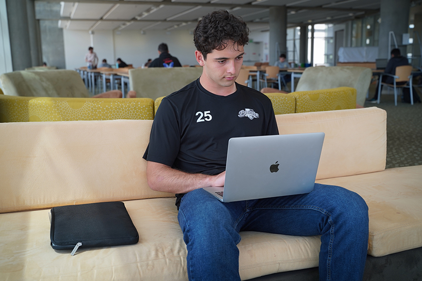 UC Merced student Edwin Casillas looks at a laptop screen while typing.