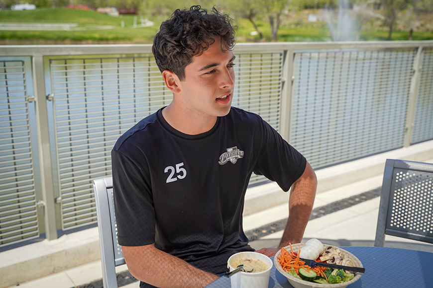 UC Merced student Edwin Casillas sits at a table while eating lunch.