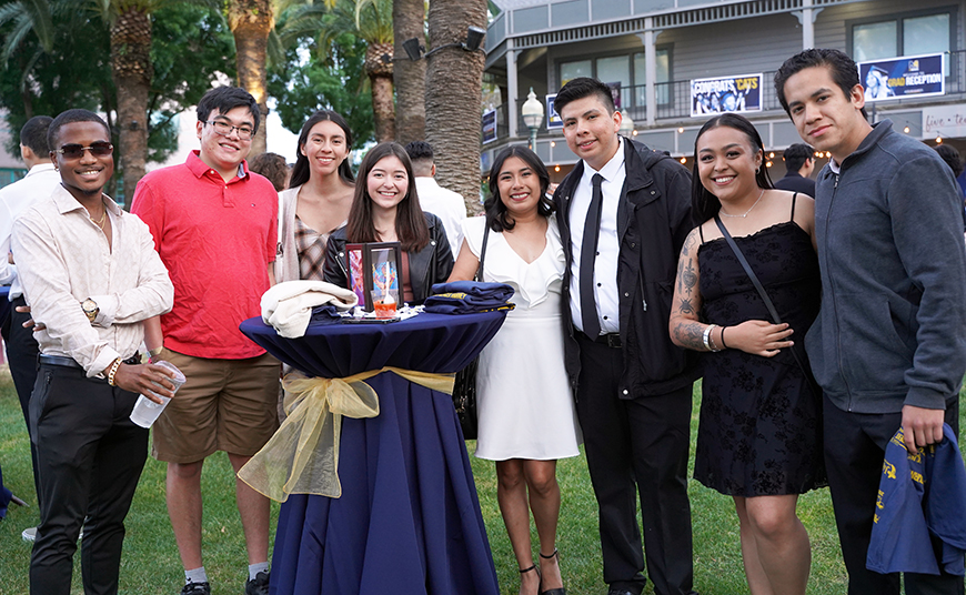 A photo shows a group of students at Grad Reception in downtown Merced.